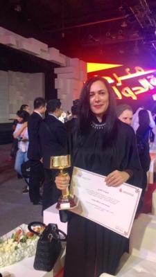 Basema Younes holding her award