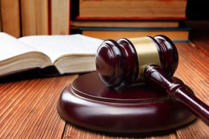 Law book and judge's gavel resting on a wooden table