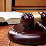 Law book and judge's gavel resting on a wooden table