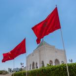 Two Moroccan flags in front of a blue sky